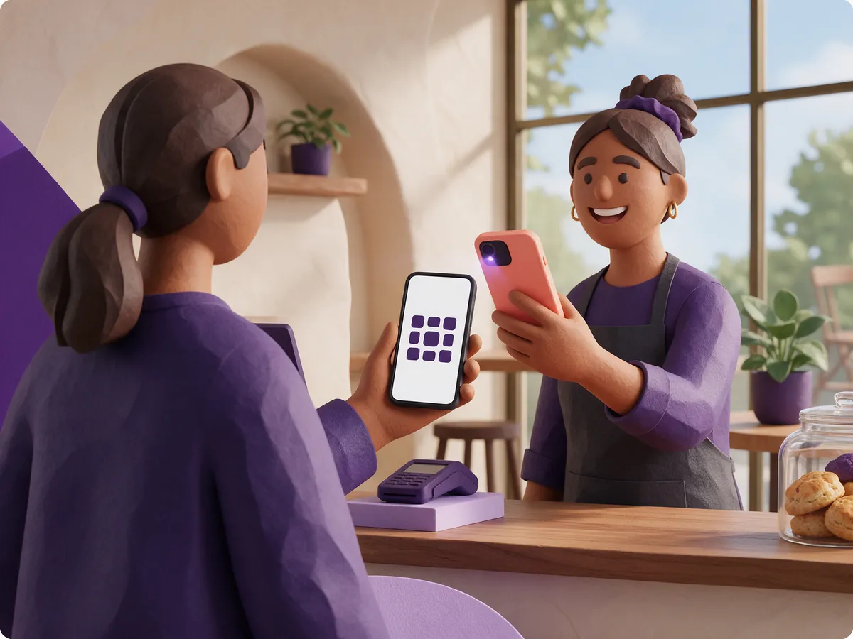 A member of staff behind the counter scanning the loyalty card on a customer's phone with their own phone.
